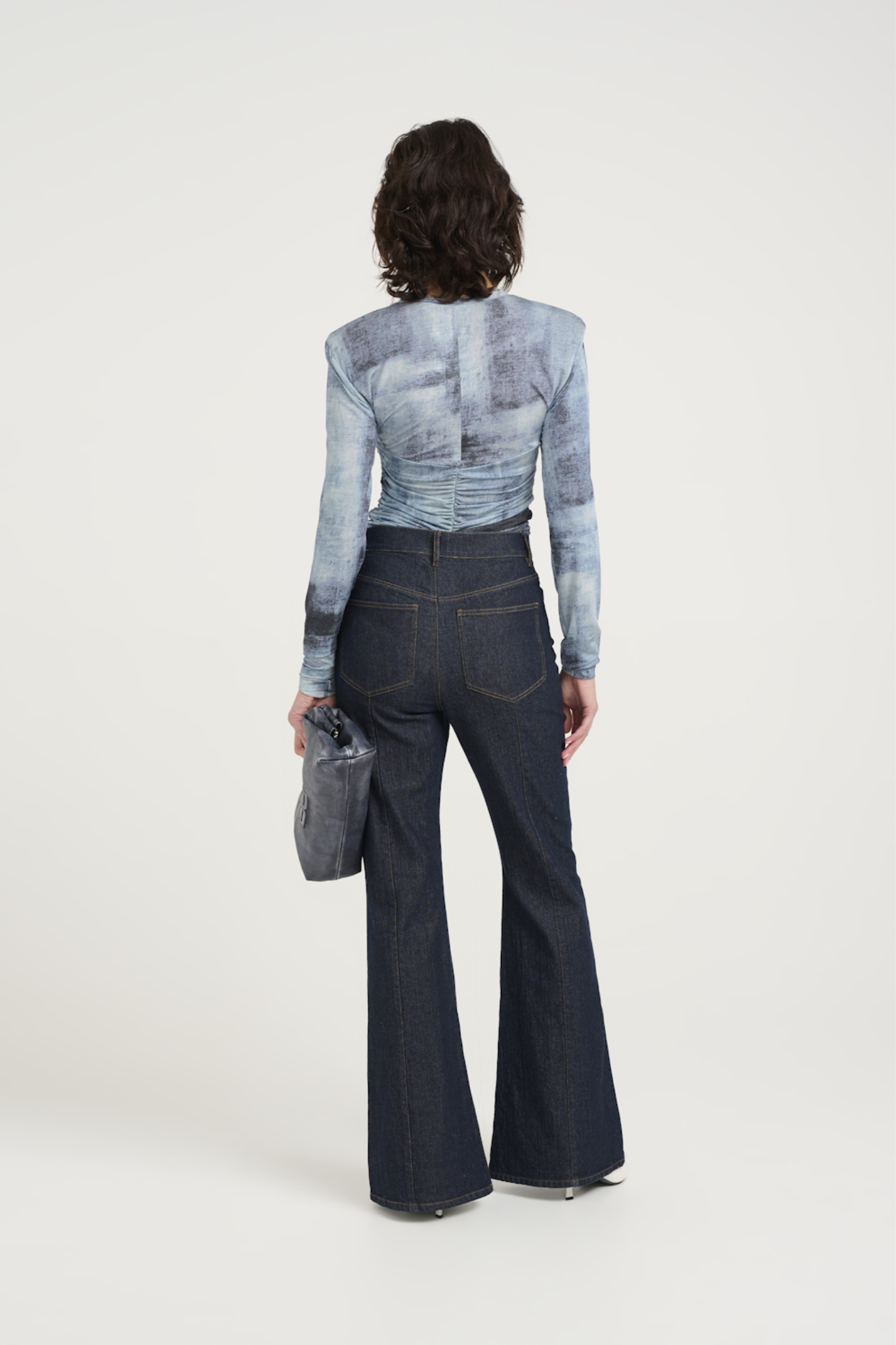 Model wearing the Gestuz areen blouse in blue denim. Back view