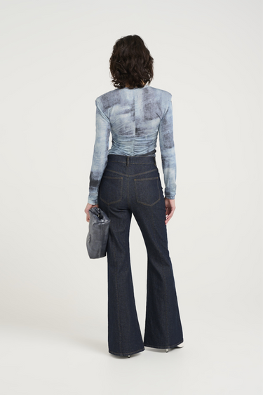 Model wearing the Gestuz areen blouse in blue denim. Back view