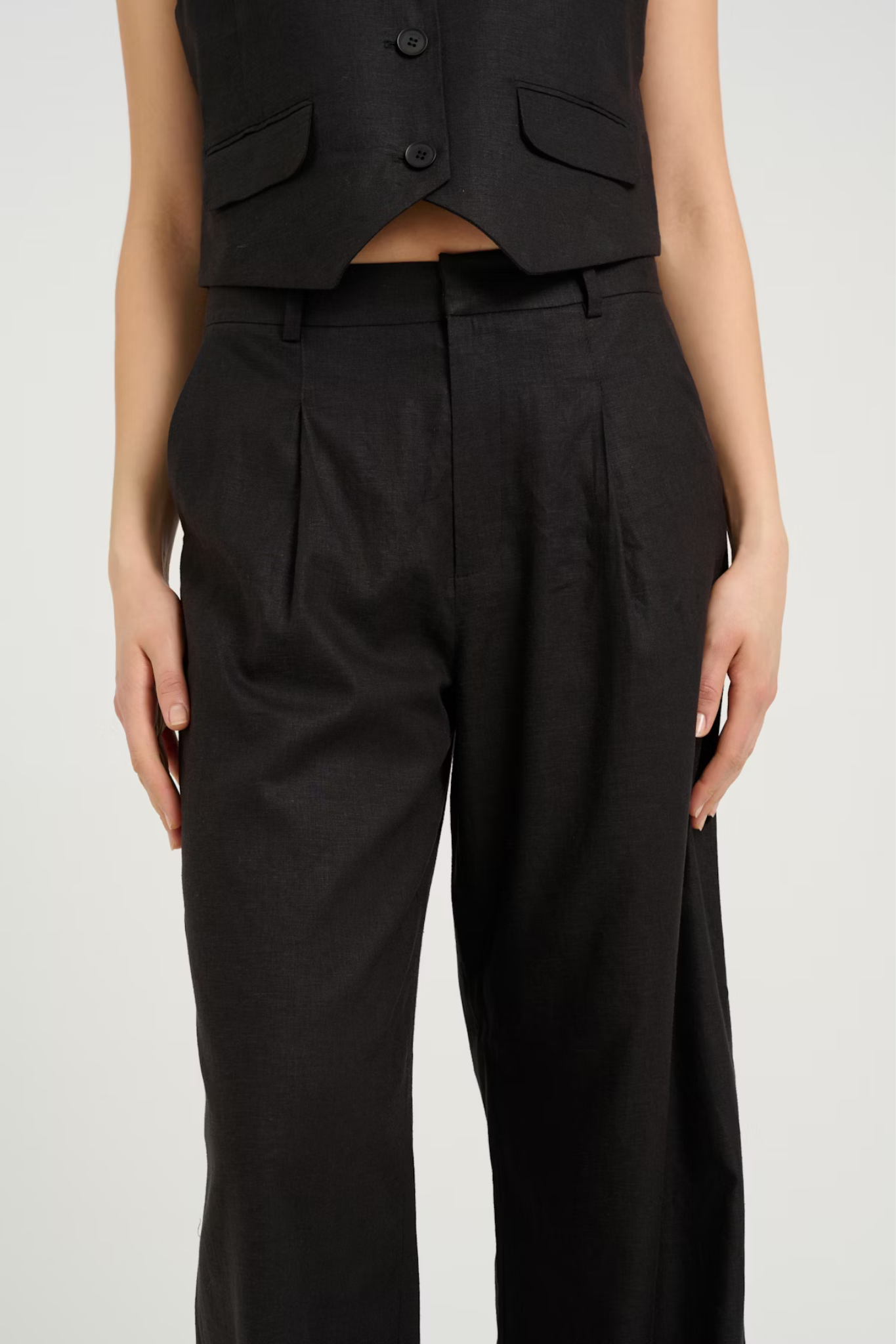 Model wearing the Gestuz elarah linen pants in black. Close front view