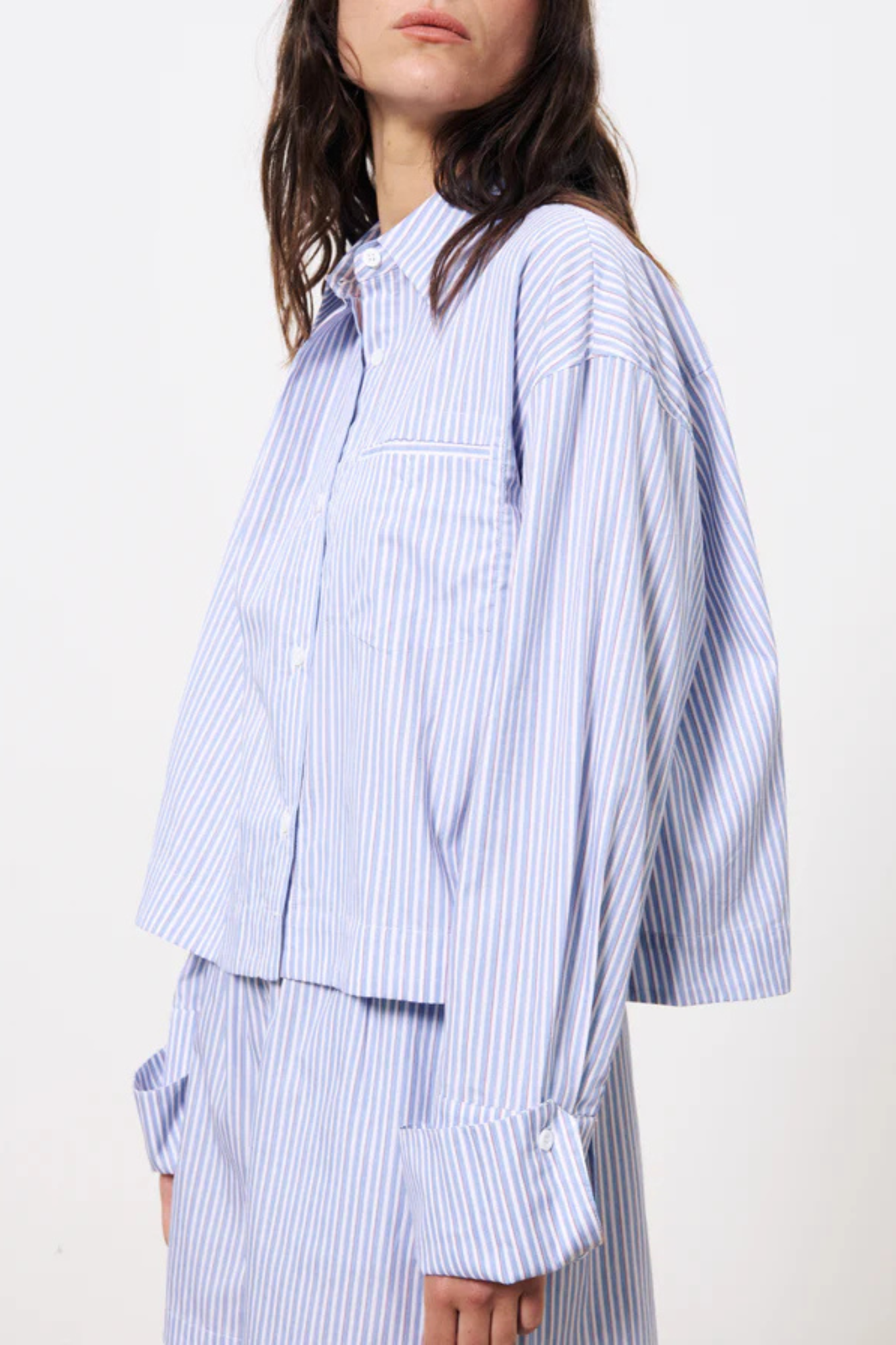 Model wearing the FRNCH naela shirt in striped blue and white. Side view