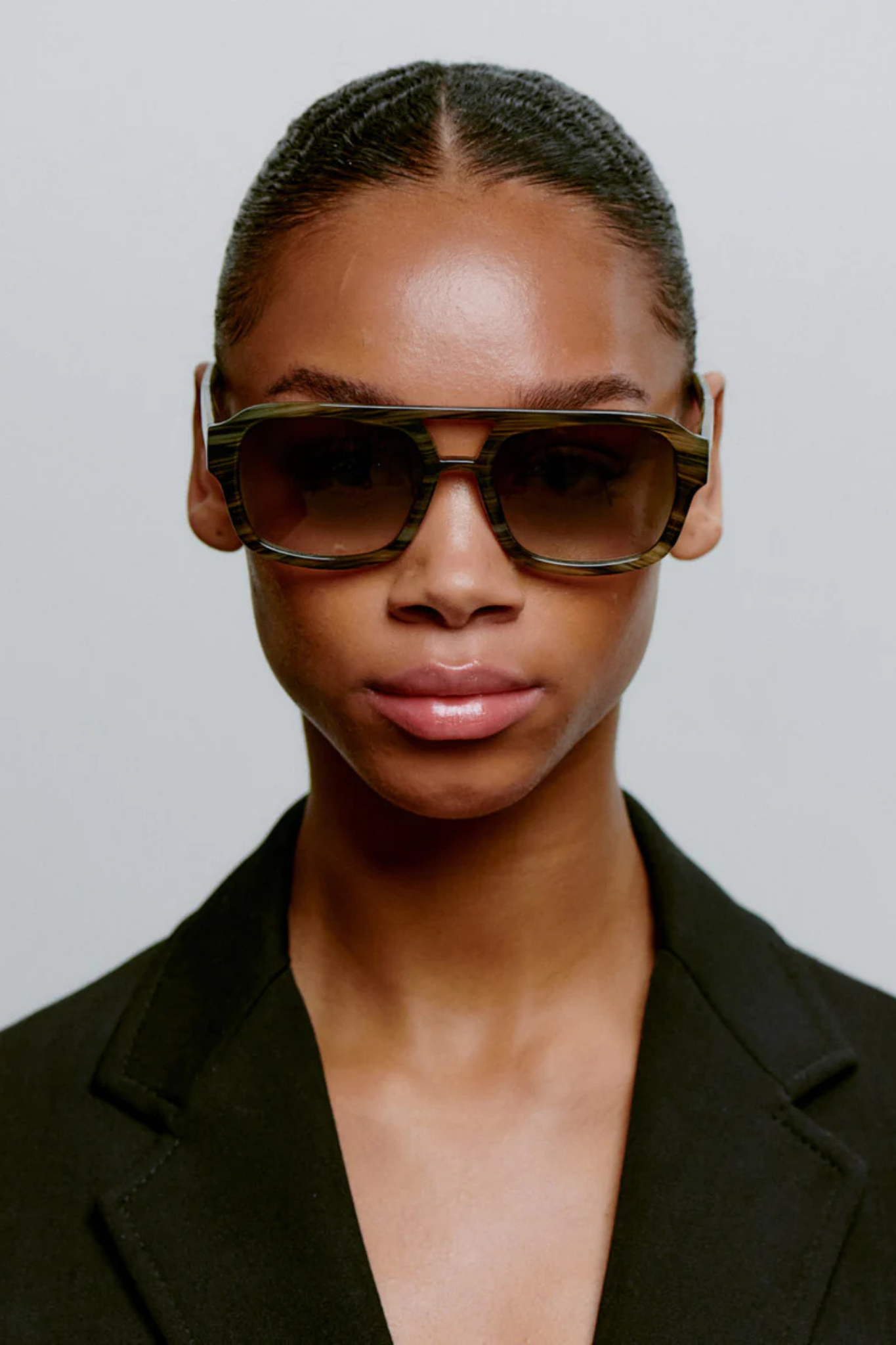 Model wearing the A. Kjaerbede kaya sunglasses in striped horn. Front view