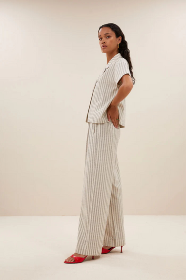 Model wearing the By-Bar Benji striped marine pants in beige and white. Side view