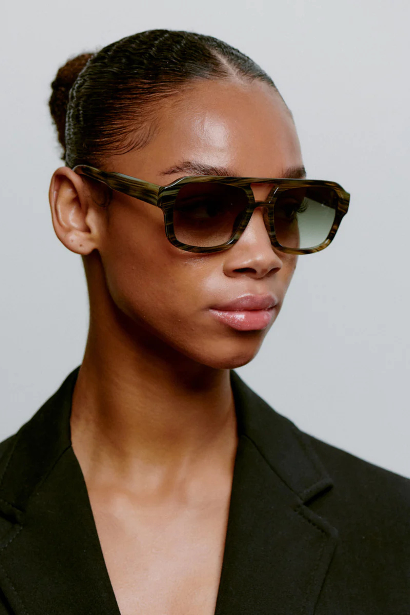 Model wearing the A. Kjaerbede kaya sunglasses in striped horn. Front view