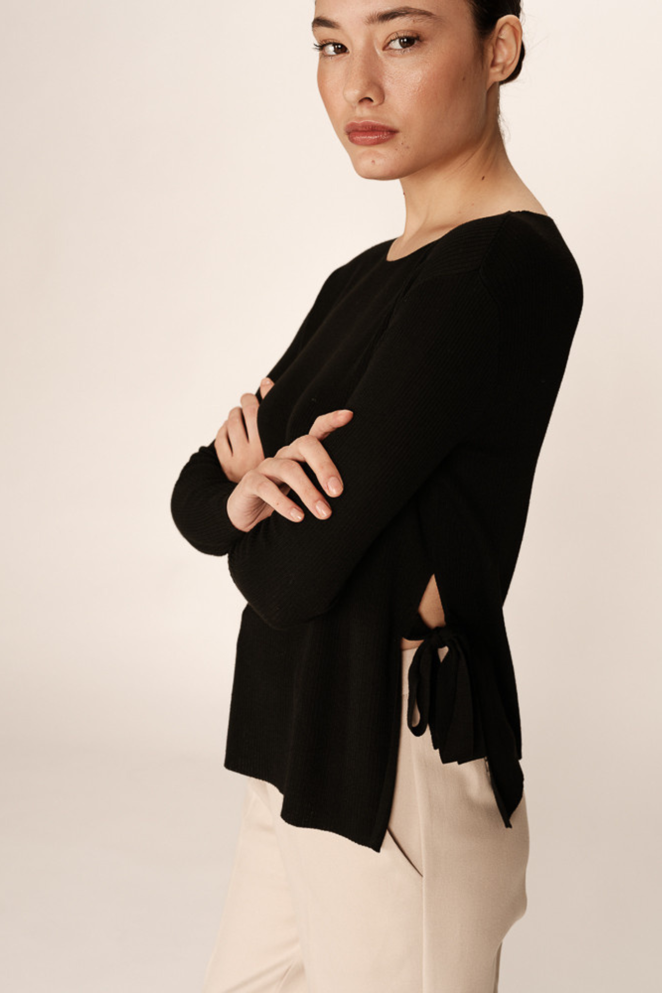 Model wearing the Grace & Mila palmer sweater in black. Side view