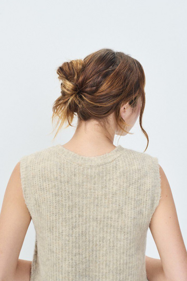 Model wearing the American Vintage beige sleeveless cardigan with logo in blue. Back view