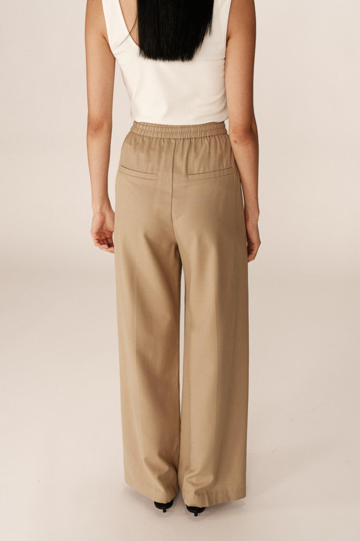 Model wearing the Grace & Mila petro pants in beige. Back view