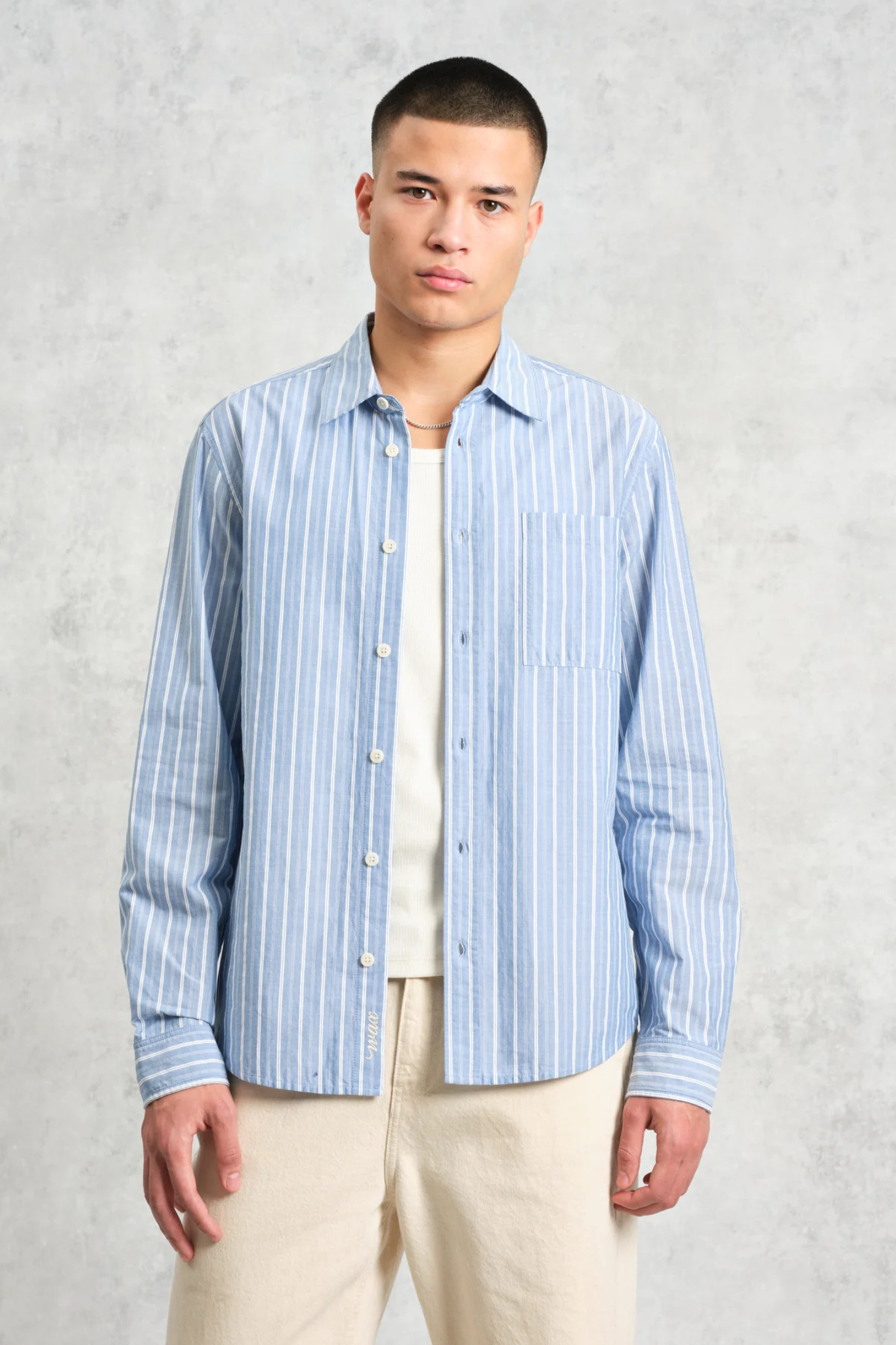 Model wearing the Wax London rove poplin stripe shirt in blue. Front view 