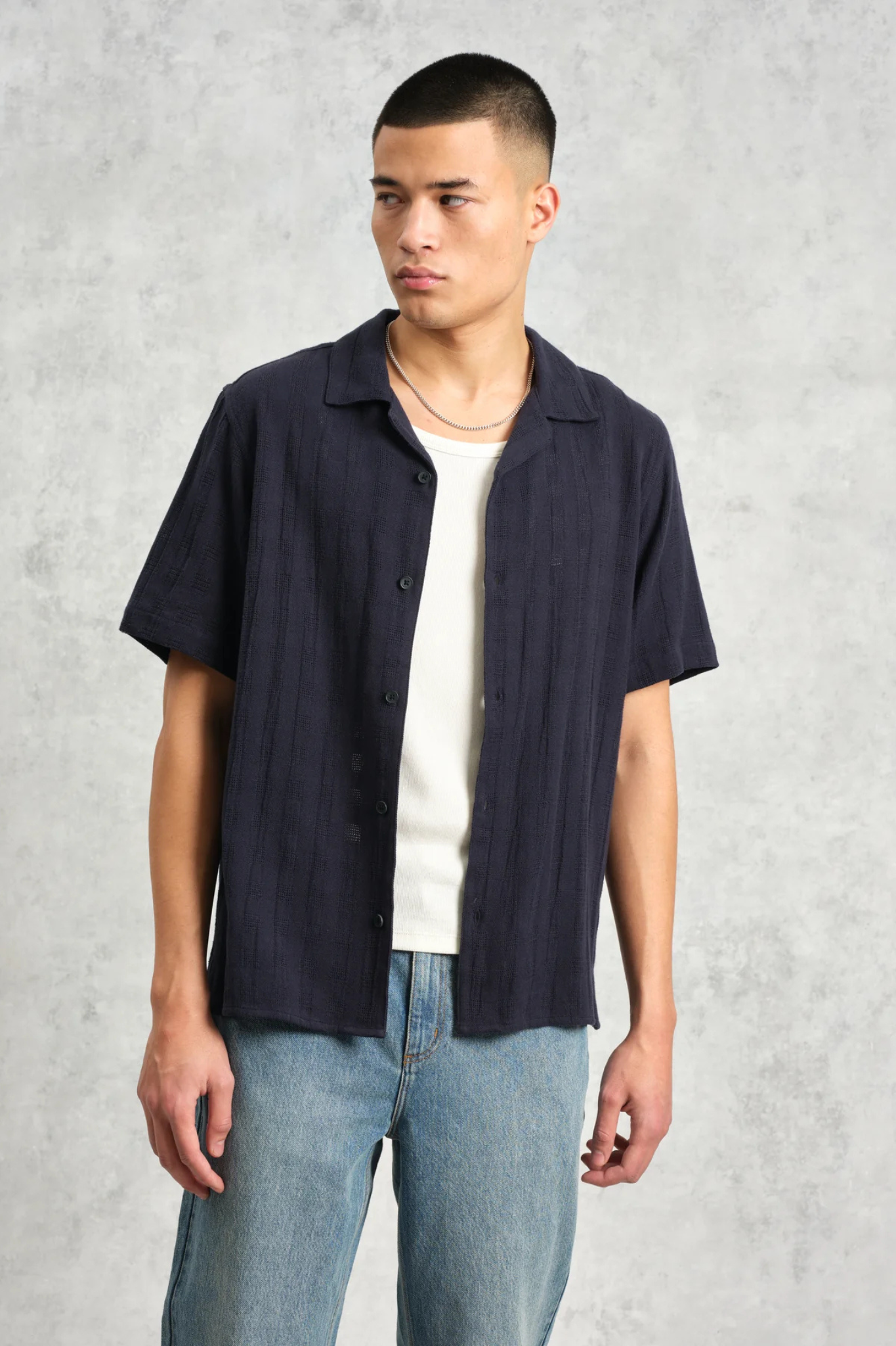 Model wearing the Wax London didcot box open weave grid shirt in navy. Front view 