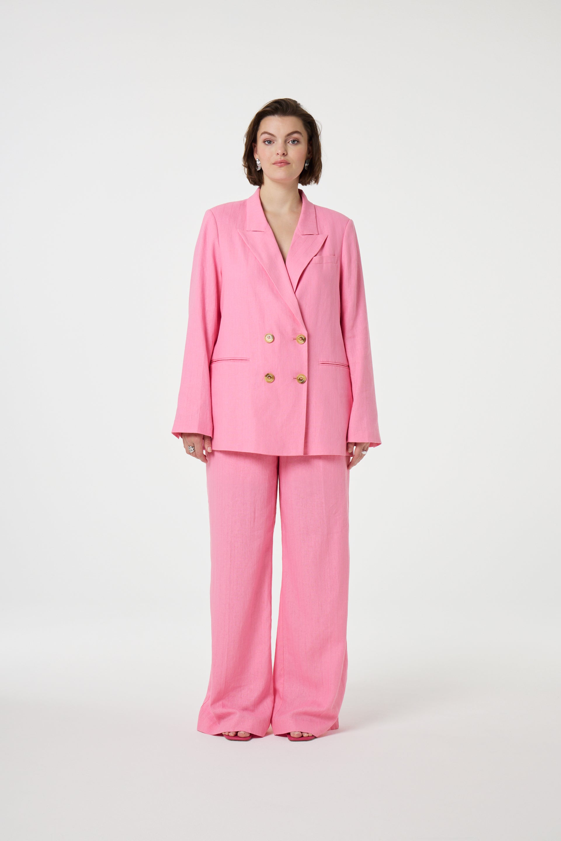 Model wearing the Fabienne Chapot nura pleated trousers in pink. Front view