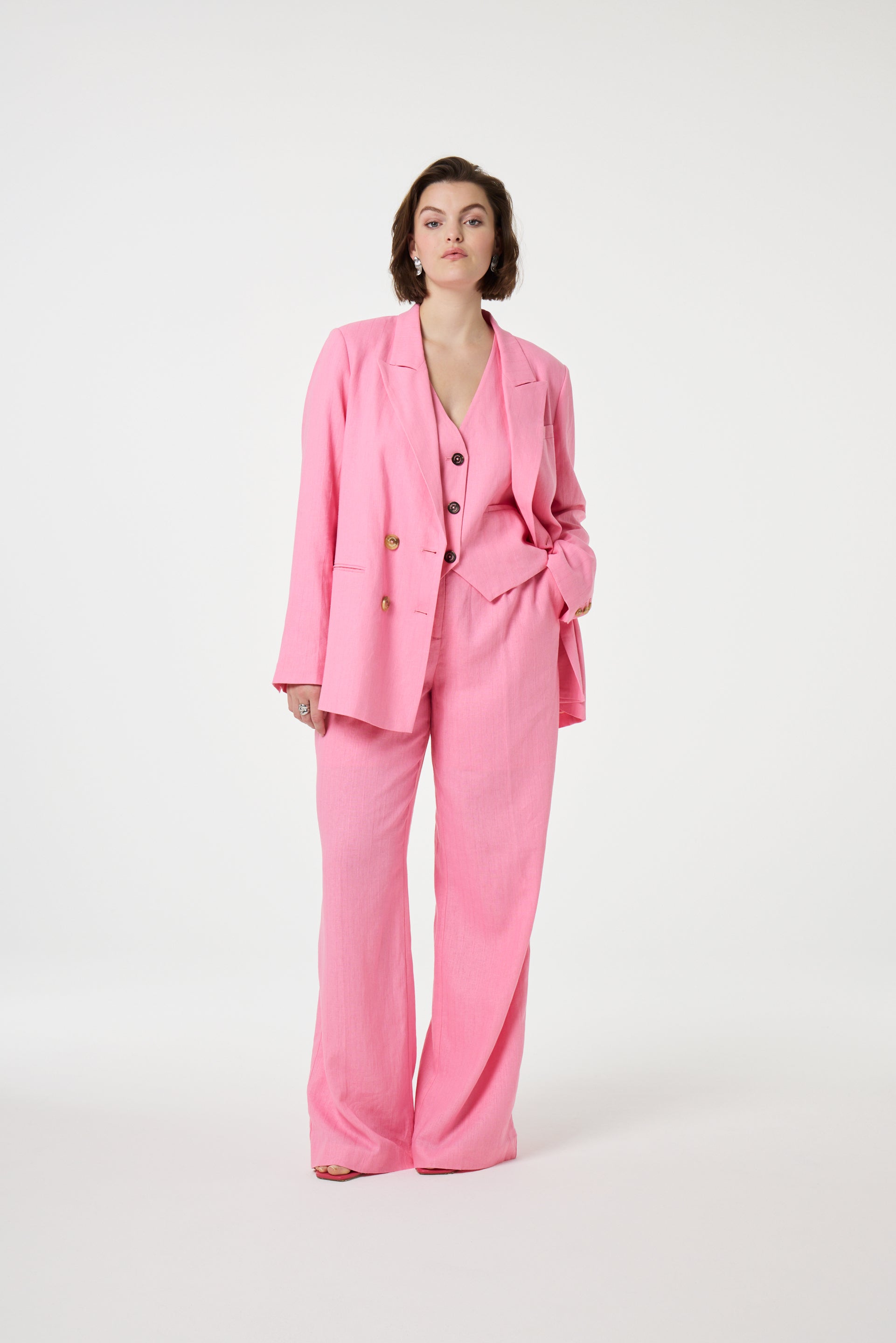 Model wearing the Fabienne Chapot nura pleated trousers in pink. Front view