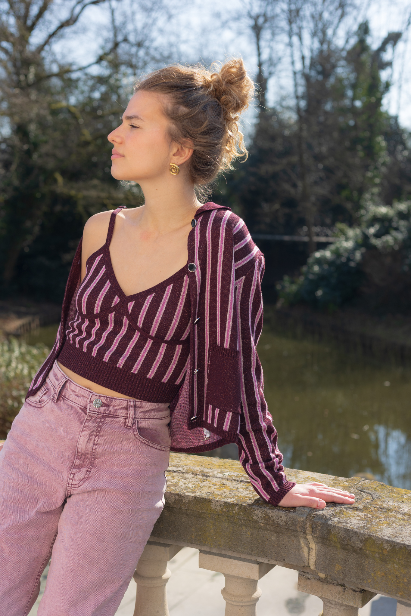 Model wearing the Baum Und Pferdgarten capera cardigan in purple and pink striped. Front view