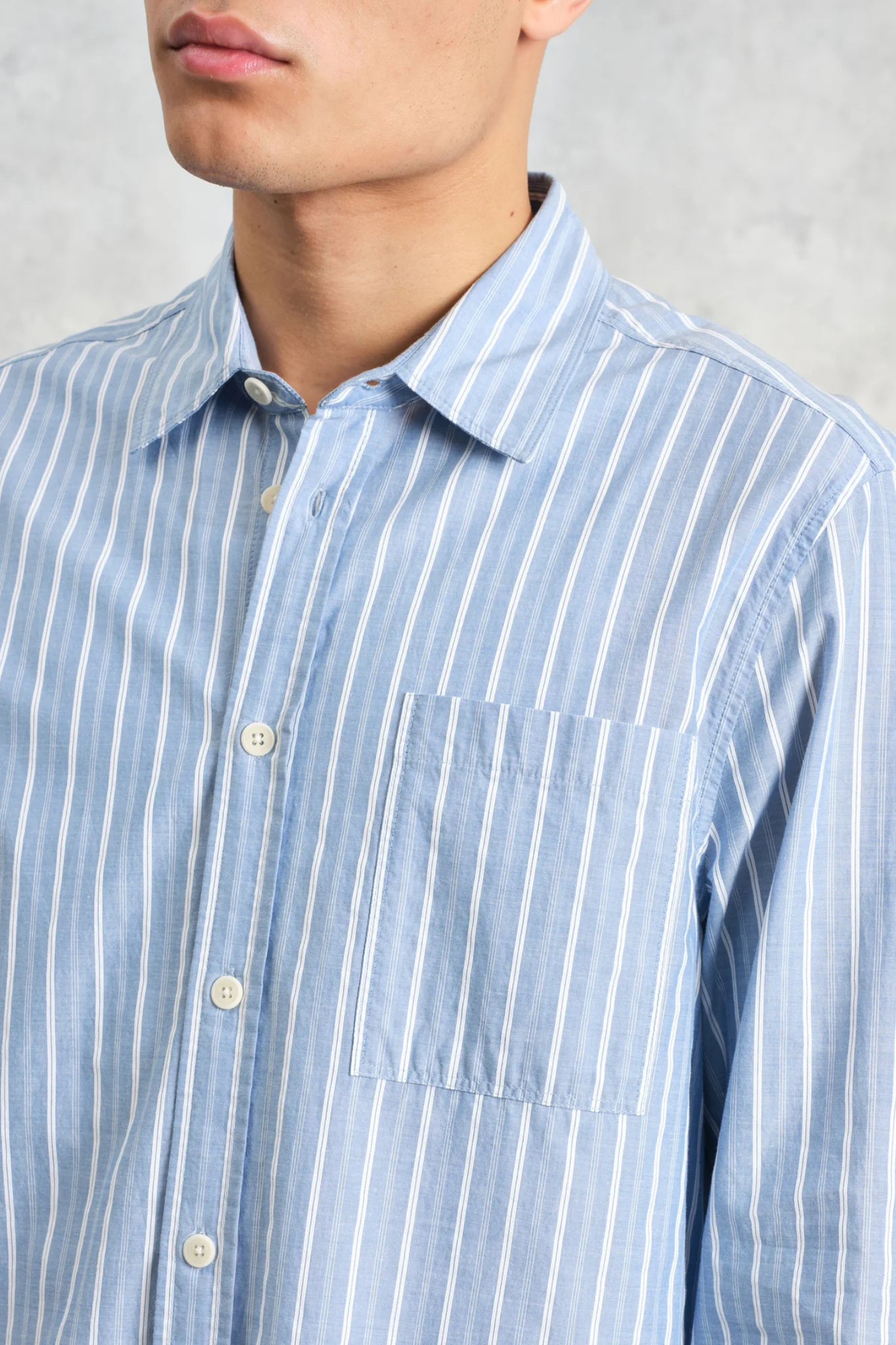 Model wearing the Wax London rove poplin stripe shirt in blue. Close front view 