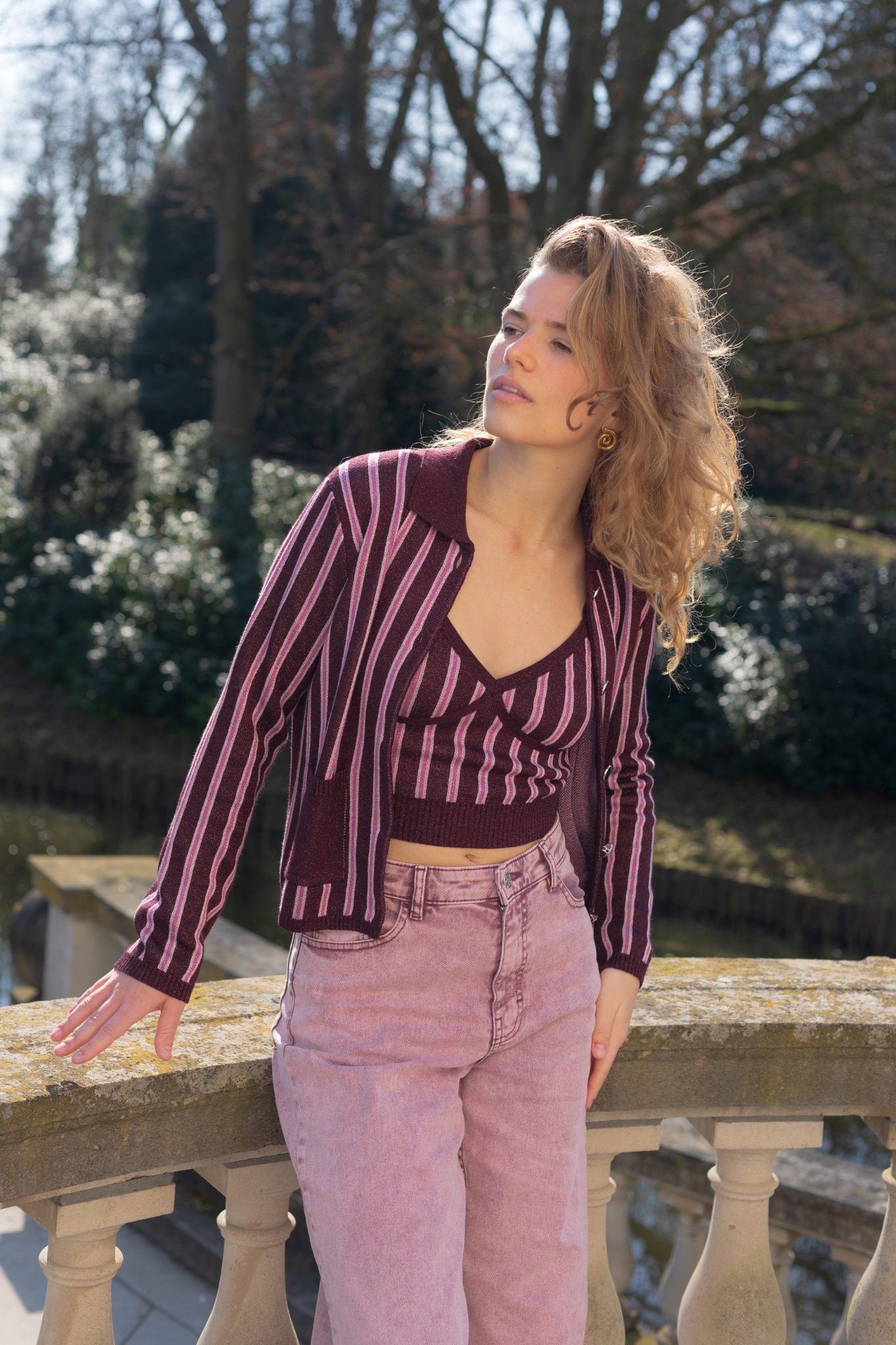 Model wearing the Baum Und Pferdgarten capera cardigan in purple and pink striped. Front view