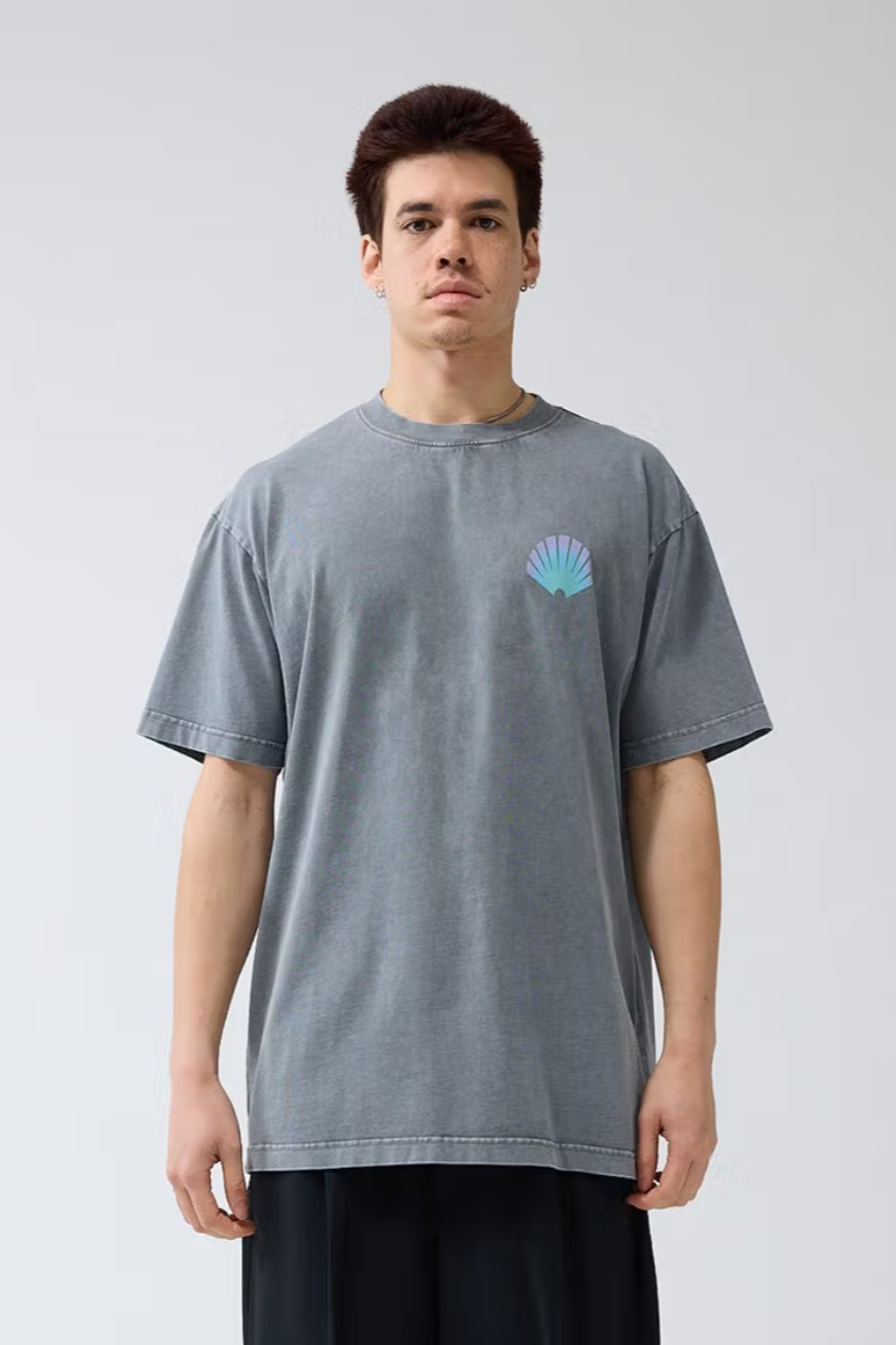 Model wearing the New Amsterdam grey logo t-shirt with logo in blue. Front view